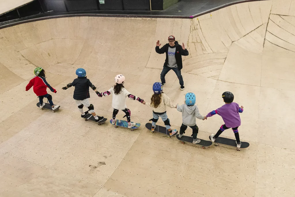 Iván Maroño dando clase de skate a seis personas en medio del bowl de la Escuela